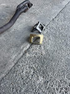 Egy autó kipufogó alkatrészeiről készült előtte-utána fotó: félig kormos és rozsdás, félig pedig már meg van tisztítva, a Balaton Lézer telephelyén.